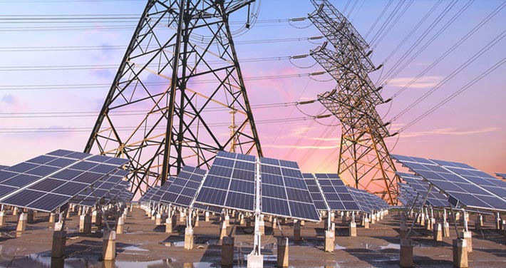 solar panels and electric transmission line against sunset
