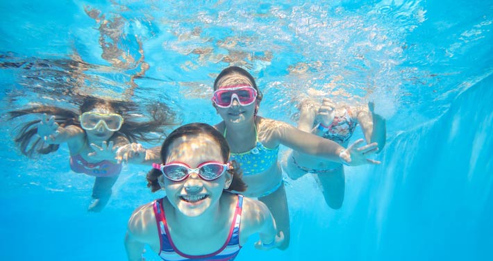 kids swimming underwater in a pool