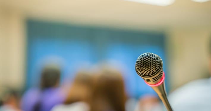 closeup of microphone with blurred people in the background