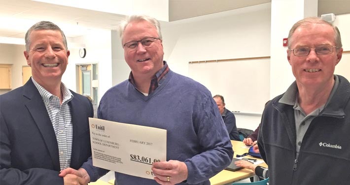 Unitil and Lunenburg School officials pose with a rebate printout