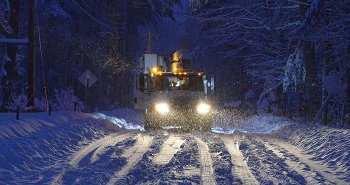 Unitil truck on snowy road at night