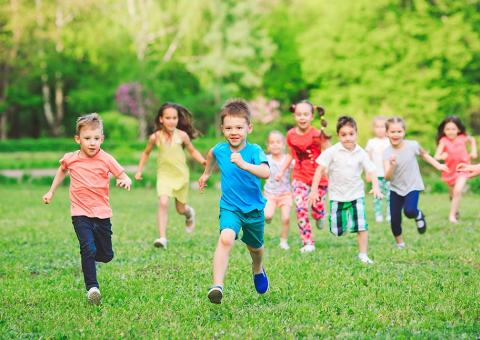 group of kids running through grass
