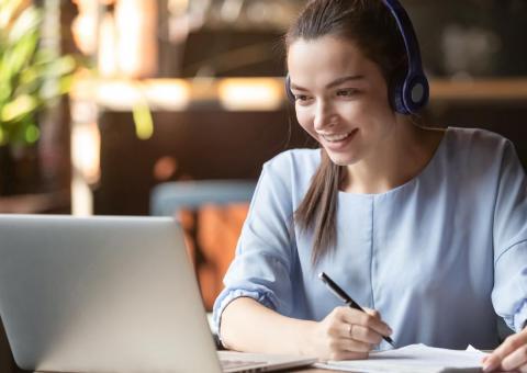woman with headphones in front of a computer